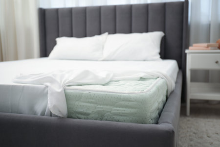 Comfortable bed with new soft mattress and pillows indoors, closeup