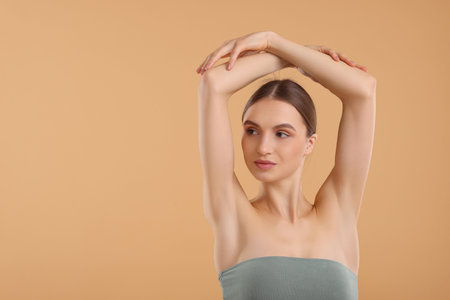 Young woman showing smooth skin after epilation on beige background, space for textの写真素材