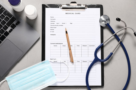 Medical card form, pen, pills and stethoscope on grey textured table, flat layの写真素材