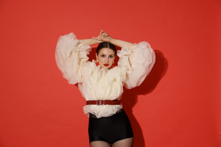 Young woman in stylish clothes on red background