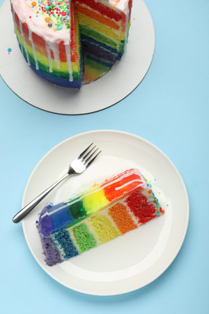 Delicious rainbow cake on light blue table, flat layの写真素材