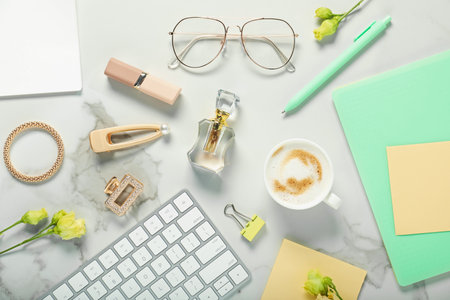 Flat lay composition with stationery, coffee and flowers on white marble tableの写真素材
