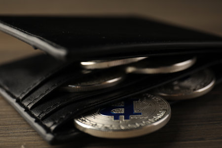 Cryptocurrency. Bitcoins in wallet on wooden background, closeupの写真素材