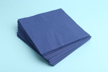Stack of disposable paper handkerchiefs on light blue background, closeupの写真素材