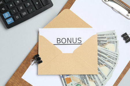 Envelope with word Bonus, money, calculator and paperwork on light grey background, flat layの写真素材