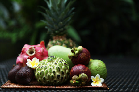 Different tropical fruit on wicker table outdoors. Space for textの写真素材