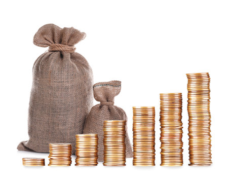 Wealth. Stacks of coins from smaller to bigger and burlap bags isolated on whiteの写真素材