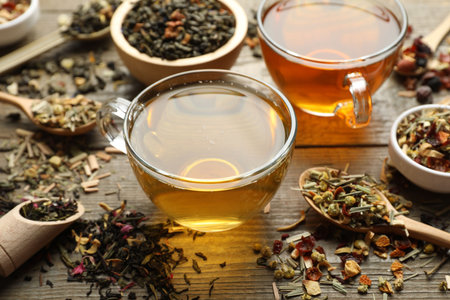 Different herbal teas and dry leaves on wooden table, closeupの写真素材