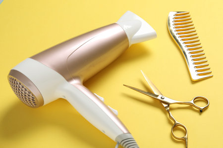 Different hairstyling tools on yellow background, closeupの写真素材