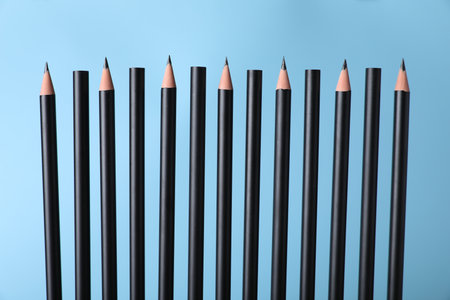 Many sharp graphite pencils on light blue background, closeupの写真素材