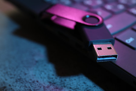 USB flash drive and laptop on dark grey table, closeupの写真素材