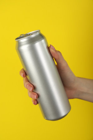 Woman with tin can on yellow background, closeupの写真素材