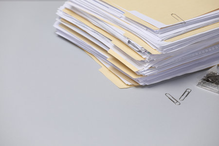 File folders with documents and paper clips on gray background, closeup. Space for textの写真素材