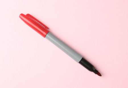 One red marker on light pink background, top view. Space for textの写真素材