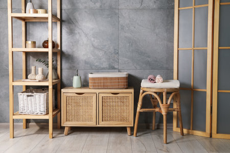 Clean waffle towels, wooden rack and dresser near grey wall in bathroomの写真素材