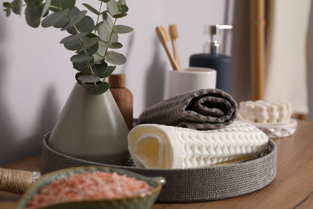 Clean waffle towels and other bath products on wooden dresser, closeup