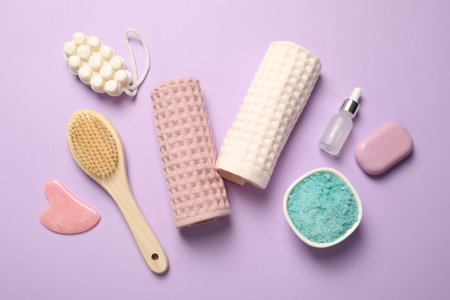 Clean waffle towels, cosmetic products and brush on violet background, flat layの写真素材