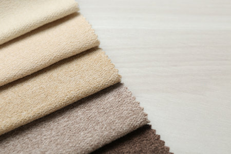 Samples of different fabrics on light wooden table, closeupの写真素材