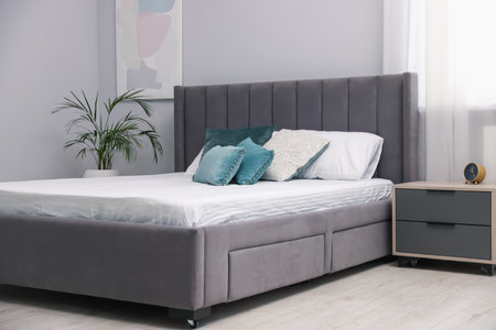 Comfortable bed with new soft mattress and pillows indoorsの写真素材