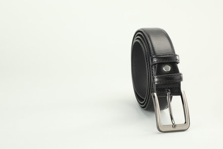 One black leather belt on white background, closeup. Space for textの写真素材