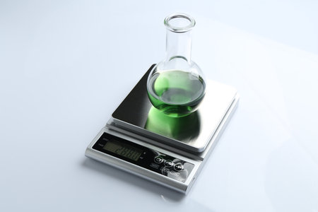 Laboratory scale with flask of sample on white backgroundの写真素材