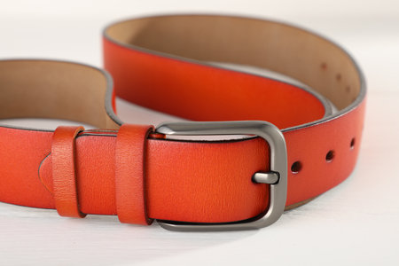 One orange leather belt on white wooden table, closeupの写真素材
