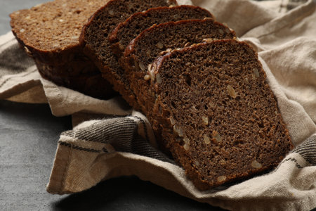 Pieces of fresh bread on black table, closeup