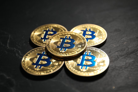 Cryptocurrency. Bitcoins on black table, closeup view