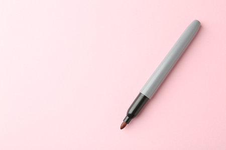 One red marker on light pink background, top view. Space for textの写真素材