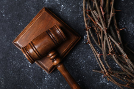 Crown of thorns and judge's gavel on dark textured background, top viewの写真素材
