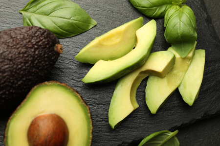 Tasty ripe green avocados and basil on table, flat layの写真素材