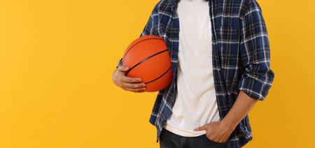 Student with basketball ball on orange background, closeup. Space for text
