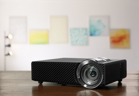Modern video projector on wooden table in art galleryの写真素材