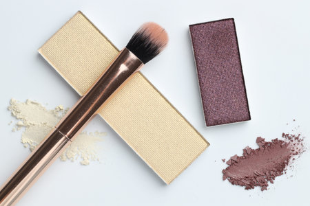 Beautiful eyeshadow refill pans and brush on white background, flat lay