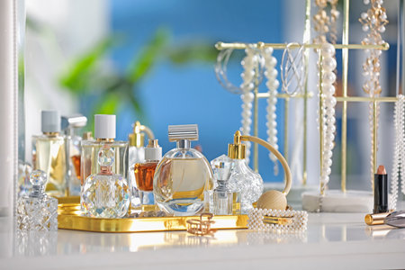 Bottles of different perfumes and accessories on table indoorsの写真素材