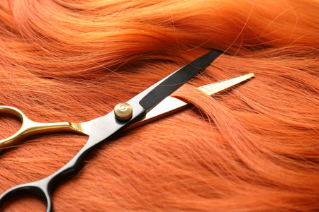 Scissors on hair lock, closeup. Hairdresser's toolの写真素材
