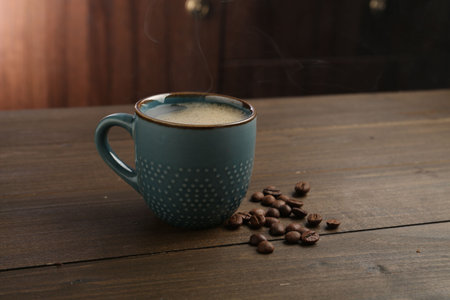 Aromatic coffee in cup and beans on wooden tableの写真素材