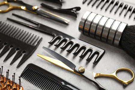 Different hairdresser's tools on grey table, closeup