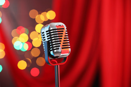 One vintage microphone against red curtain, space for text. Bokeh effectの写真素材