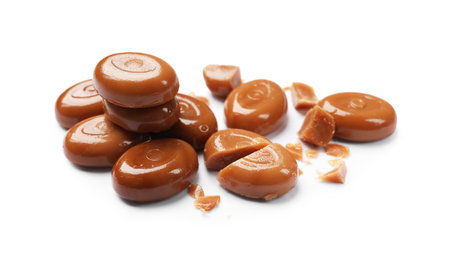 Broken tasty caramel candies isolated on whiteの写真素材