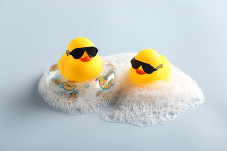 Cute rubber ducks, foam and inflatable ring on white backgroundの写真素材
