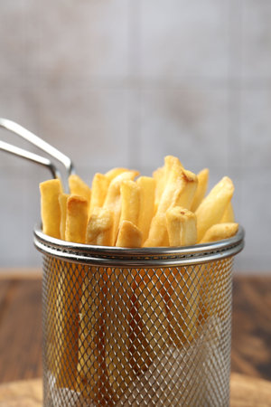 Tasty french fried served on wooden table, closeup