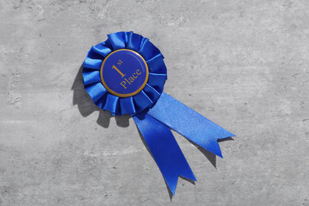 Blue award ribbon on light grey table, top viewの写真素材