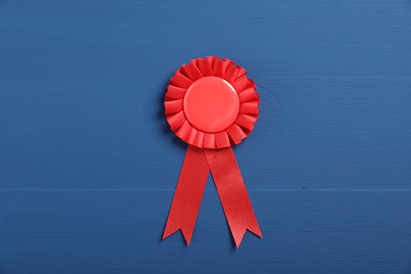 Red award ribbon on blue wooden table, top viewの写真素材