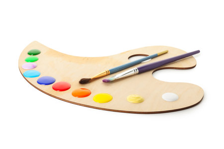 Wooden palette with paints and brushes isolated on whiteの写真素材