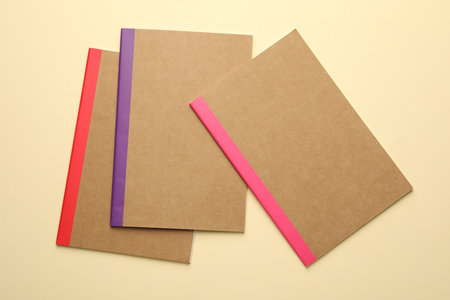Different copybooks on beige background, flat lay