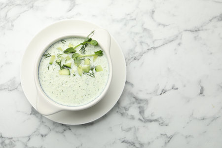 Tasty cucumber soup with dill and microgreens on white marble table, top view. Space for textの写真素材