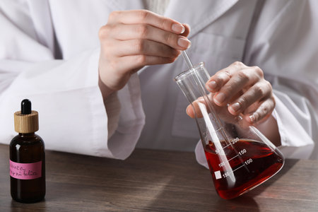 Professional perfumer developing luxury perfume at wooden table in laboratory, closeupの写真素材