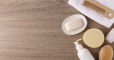 Different bath accessories on wooden background, flat lay. Space for text