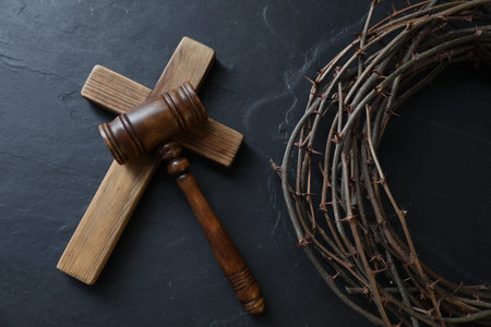 Judge's gavel, crown of thorns and wooden cross on black table, flat layの写真素材